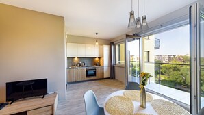 En modern lägenhet med kök, matplats och stora fönster med utsikt över staden.