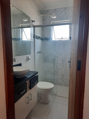 Chuveiro, toalhas de banho, papel higiênico