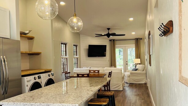 A modern kitchen with a central island, built-in appliances, and pendant lighting.