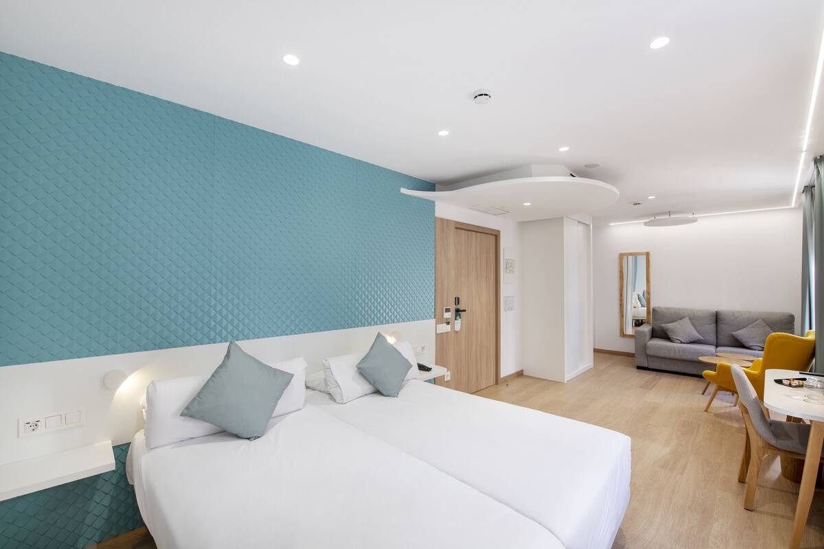 Ein modernes Hotelzimmer mit einem großen Bett, einem Schreibtisch und einer Sitzecke.