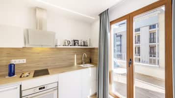 A modern kitchen with white cabinets, a wooden countertop, and a built-in oven.