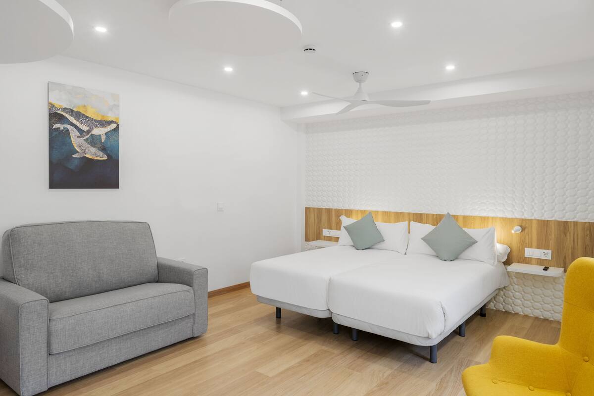 Ein Hotelzimmer mit einem Bett, einem Sofa und einem Sessel.