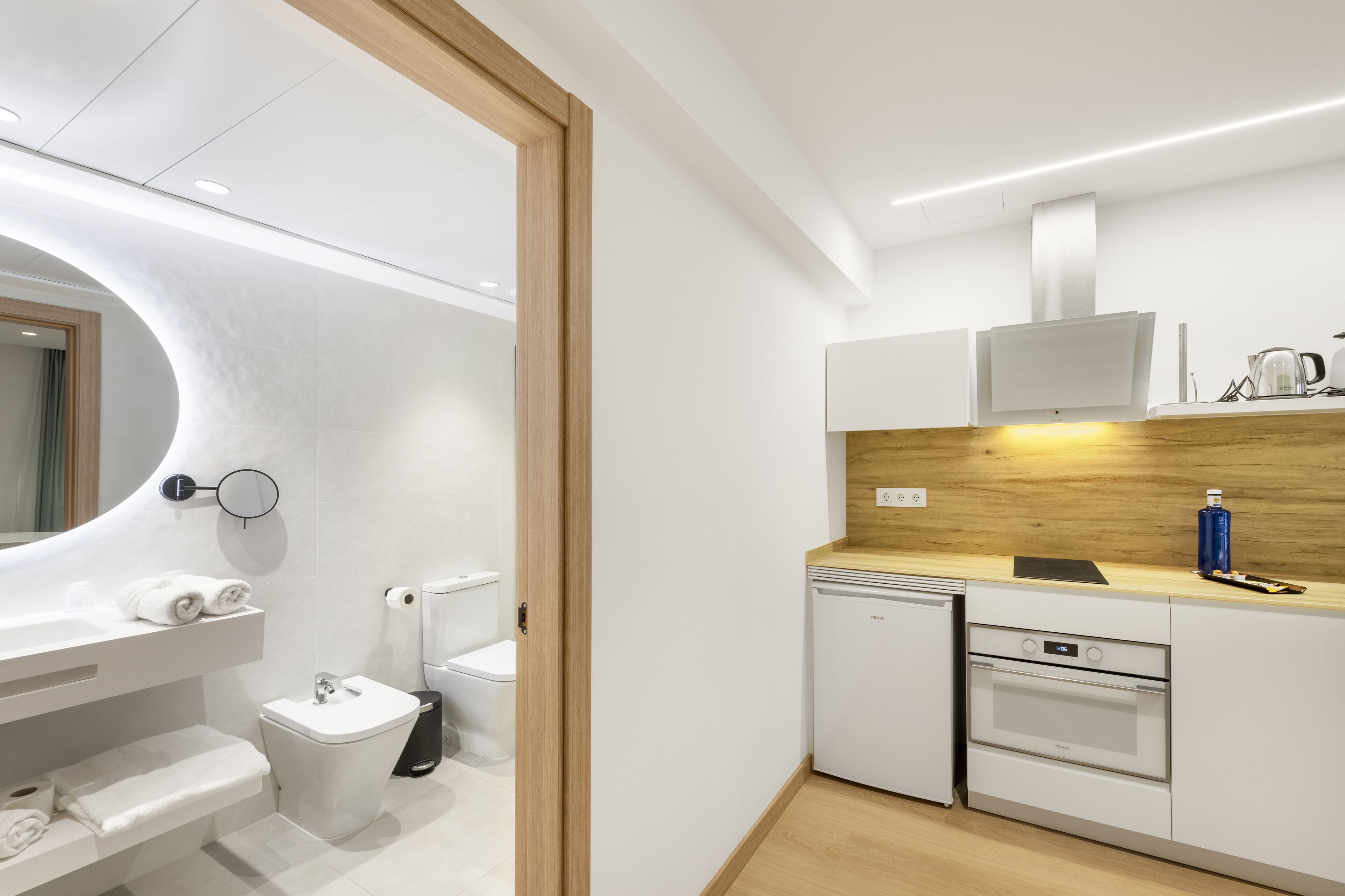 A modern kitchen with white cabinets, a built-in oven, and a microwave.
