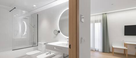 Ein modernes Badezimmer mit einer Duschkabine, einem weißen Waschbecken und einer Toilette.