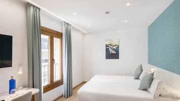 Une chambre moderne avec un lit, un bureau, une chaise, une fenêtre avec des rideaux, un tableau et un panneau acoustique bleu sur le mur.