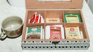 Una caja con varios sobre de té y una taza.