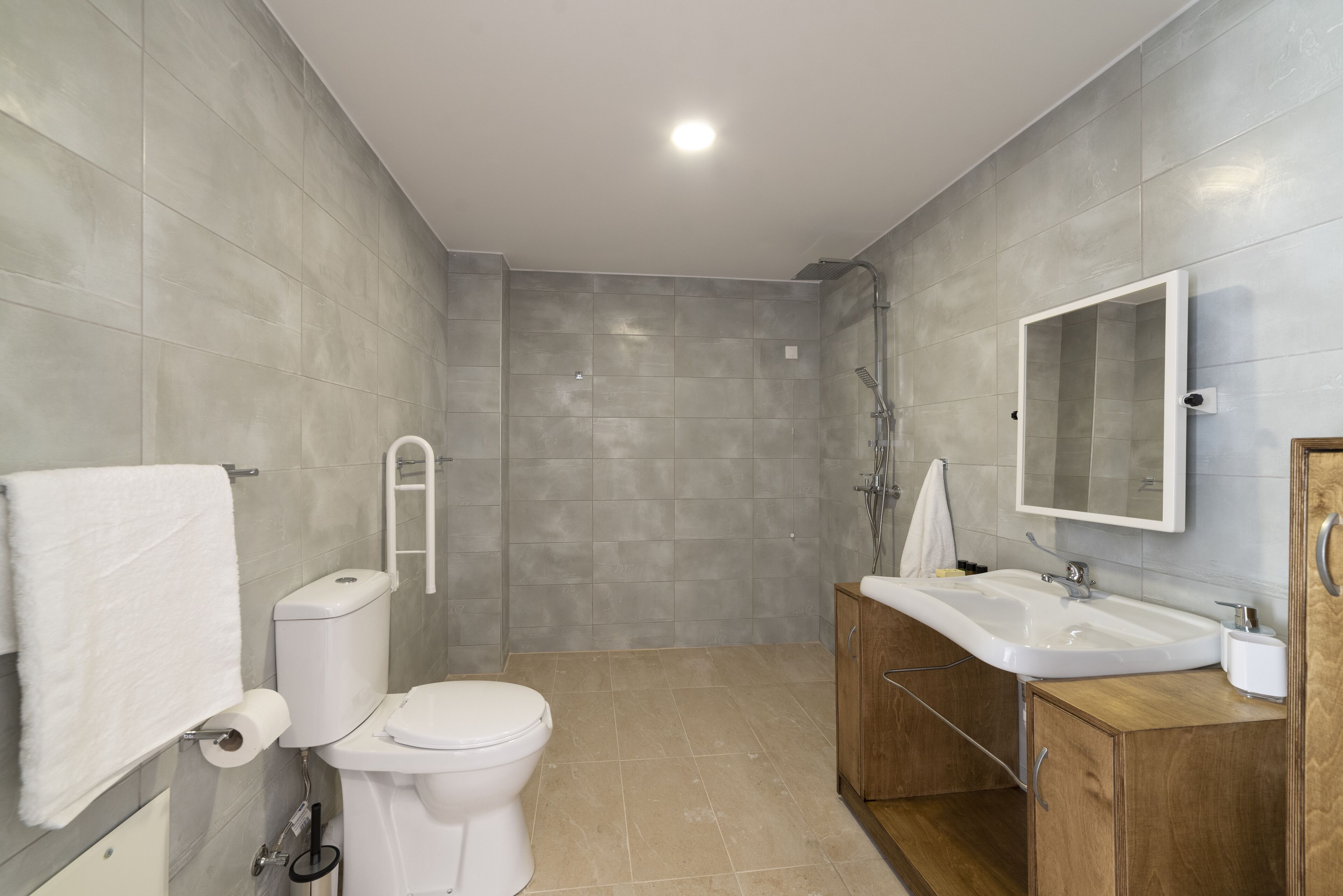 A modern bathroom with a toilet, sink, and shower.