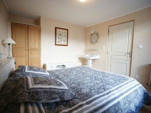 Cozy retreat with a large bed, wardrobe, and bedside table.