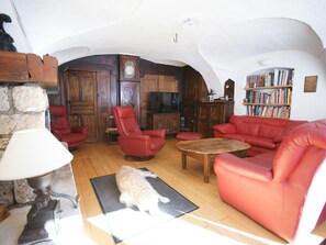 Cozy living room with a fireplace, comfortable seating, and a bookshelf.