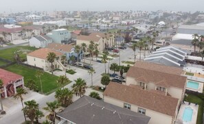 A residential area with houses, palm trees, and a swimming pool. - EZ Walk to Beach * Swanky 2 bedroom * Sleeps Tons (Mar y Sol II #1) by RedAwning (South Padre Island)