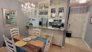 A dining area with a table, chairs, and a chandelier.