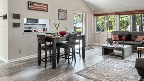 Una sala moderna con comedor, ventanas amplias y ventilador de techo.