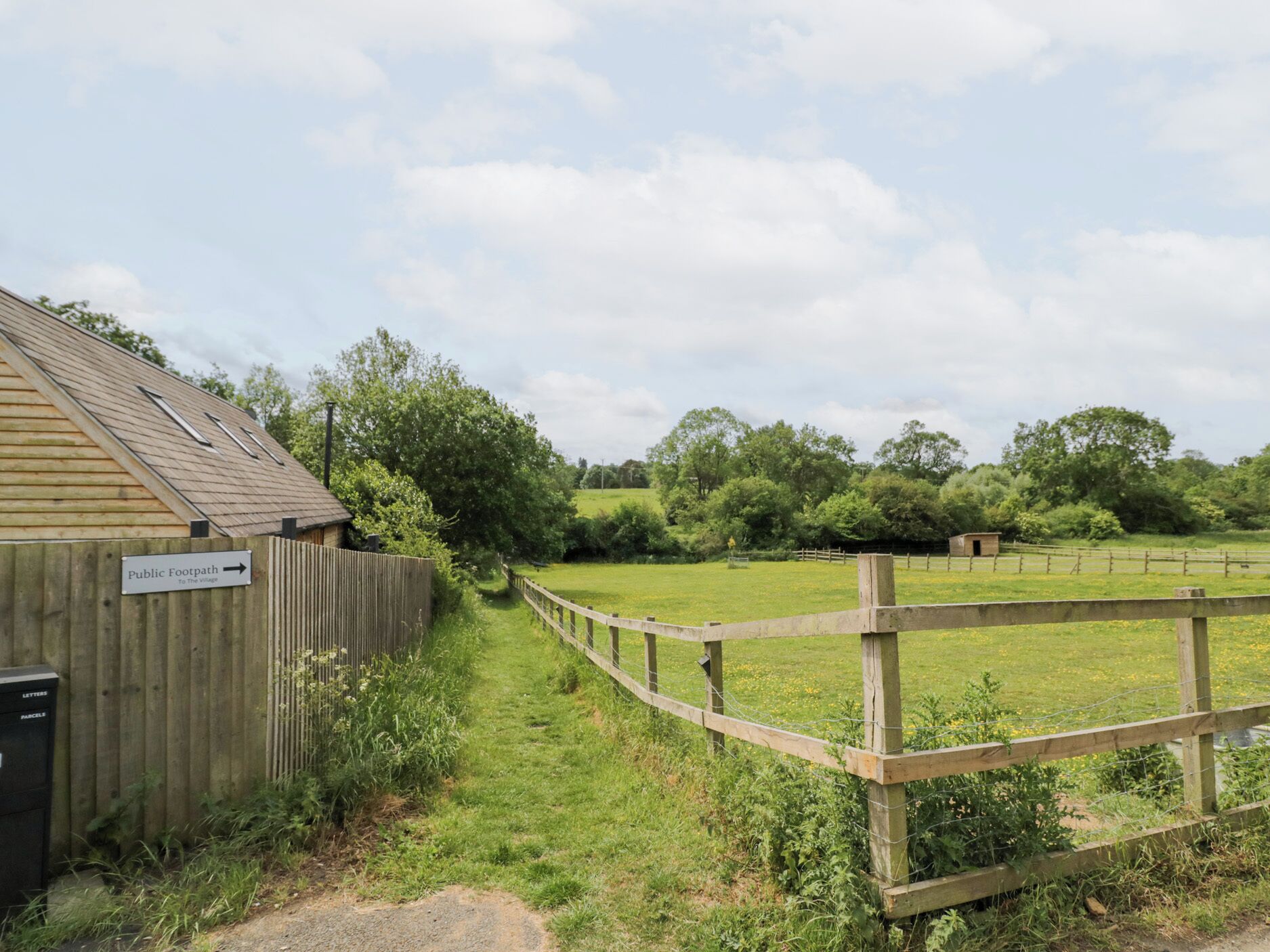 A wooden fence leading to a public footpath to the village.