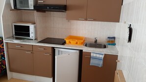 Una cucina compatta con forno a microonde, tostapane, lavello e lavastoviglie.