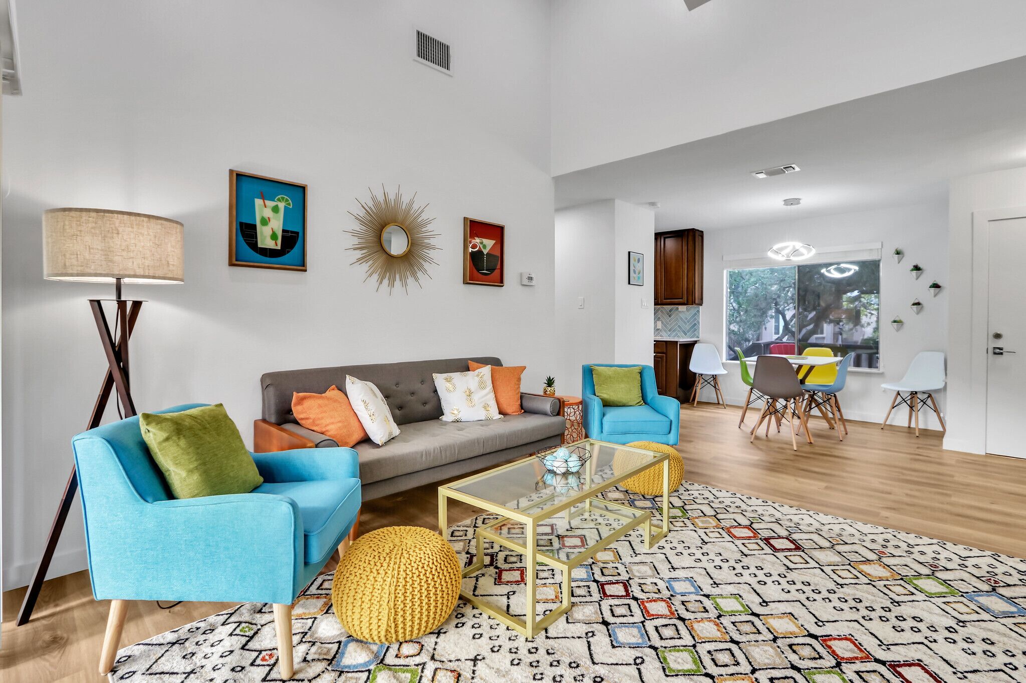 A spacious living room with a sofa, armchairs, a coffee table, and a dining area with chairs.