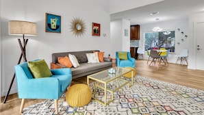 A spacious living room with a sofa, armchairs, a coffee table, and a dining area with chairs. - Groovy Getaway | Lake Access, Pool, Tennis, 72-Hr Boat Parking (Canyon Lake)