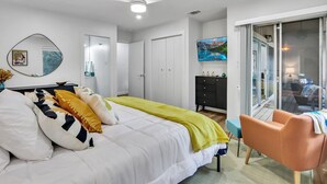 A modern bedroom with a bed, a desk, a chair, and a sliding glass door leading to a balcony. - Groovy Getaway | Lake Access, Pool, Tennis, 72-Hr Boat Parking (Canyon Lake)