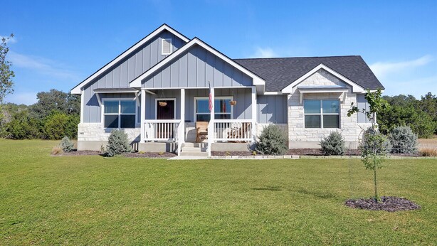 A two-story house with a front porch, a garage, and a well-maintained lawn. - Come stay at the Oasis by the Lake! (Canyon Lake)