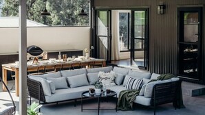 Ein moderner Außenbereich mit Ecksofa, Esstisch und Stühlen.