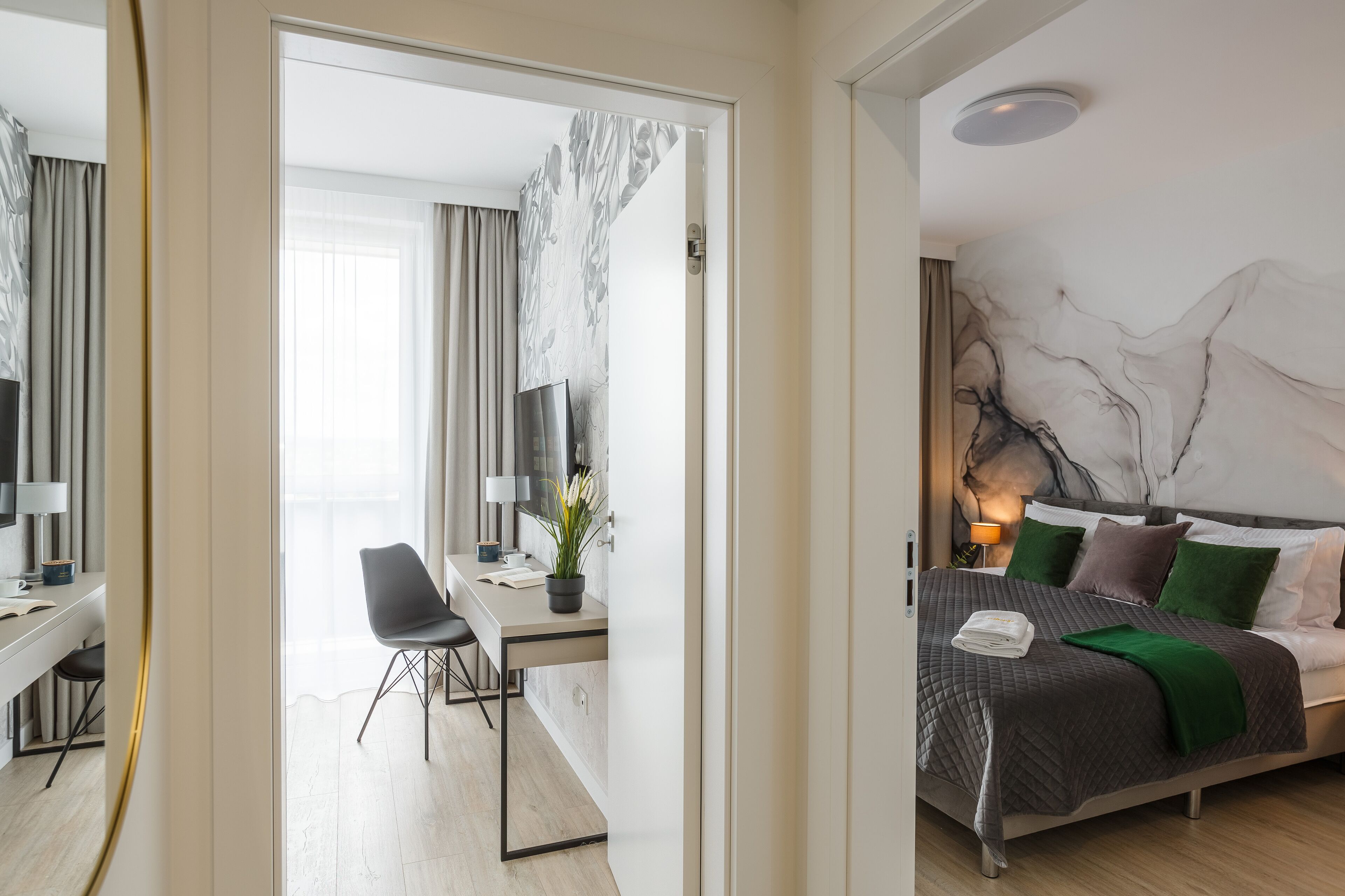 Una camera d'albergo moderna con un letto, una scrivania e una sedia.
