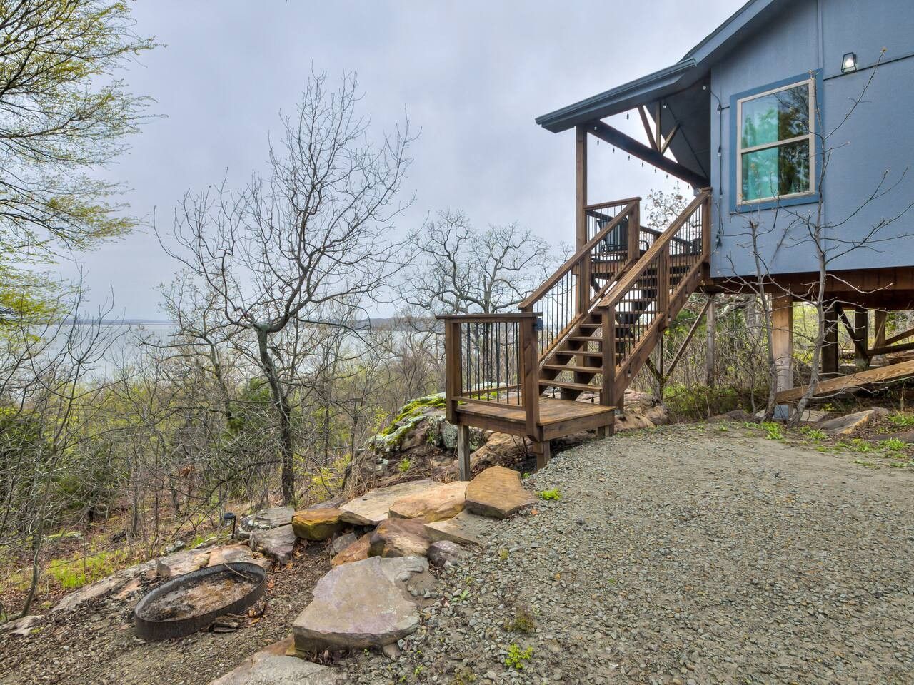 A wooden staircase leading to a house with a view of a body of water.