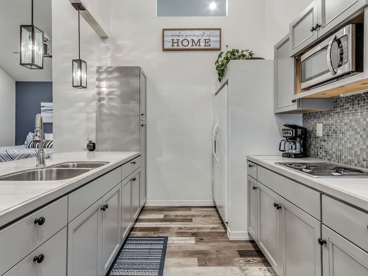 A modern kitchen with a stainless steel refrigerator, a microwave, and a coffee maker on the counter.