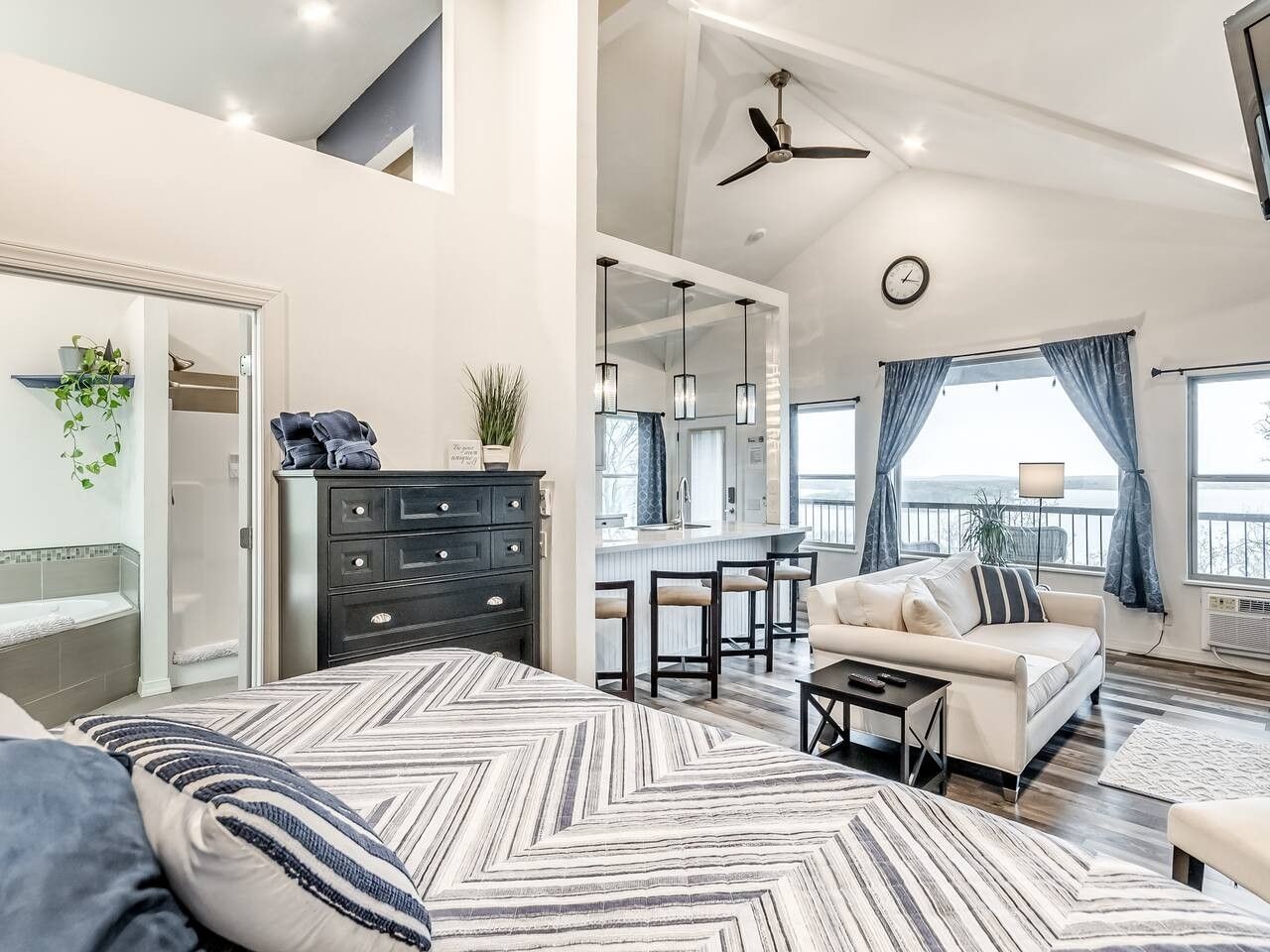 A spacious living area with a sofa, a dining table, and a kitchen in the background.