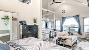 A spacious living area with a sofa, a dining table, and a kitchen in the background.