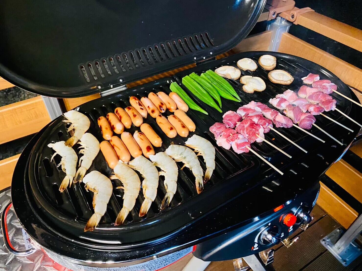 A grill with various meats and vegetables.