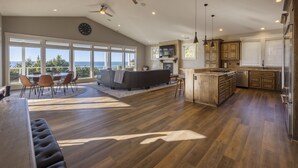 A spacious kitchen with a large island, built-in appliances, and a dining area with a view. - Point Break at Agate Beach, Sleeps 12, Oceanfront, Loft, Game Room, Hot Tub, Beach Access, BBQ (Newport)
