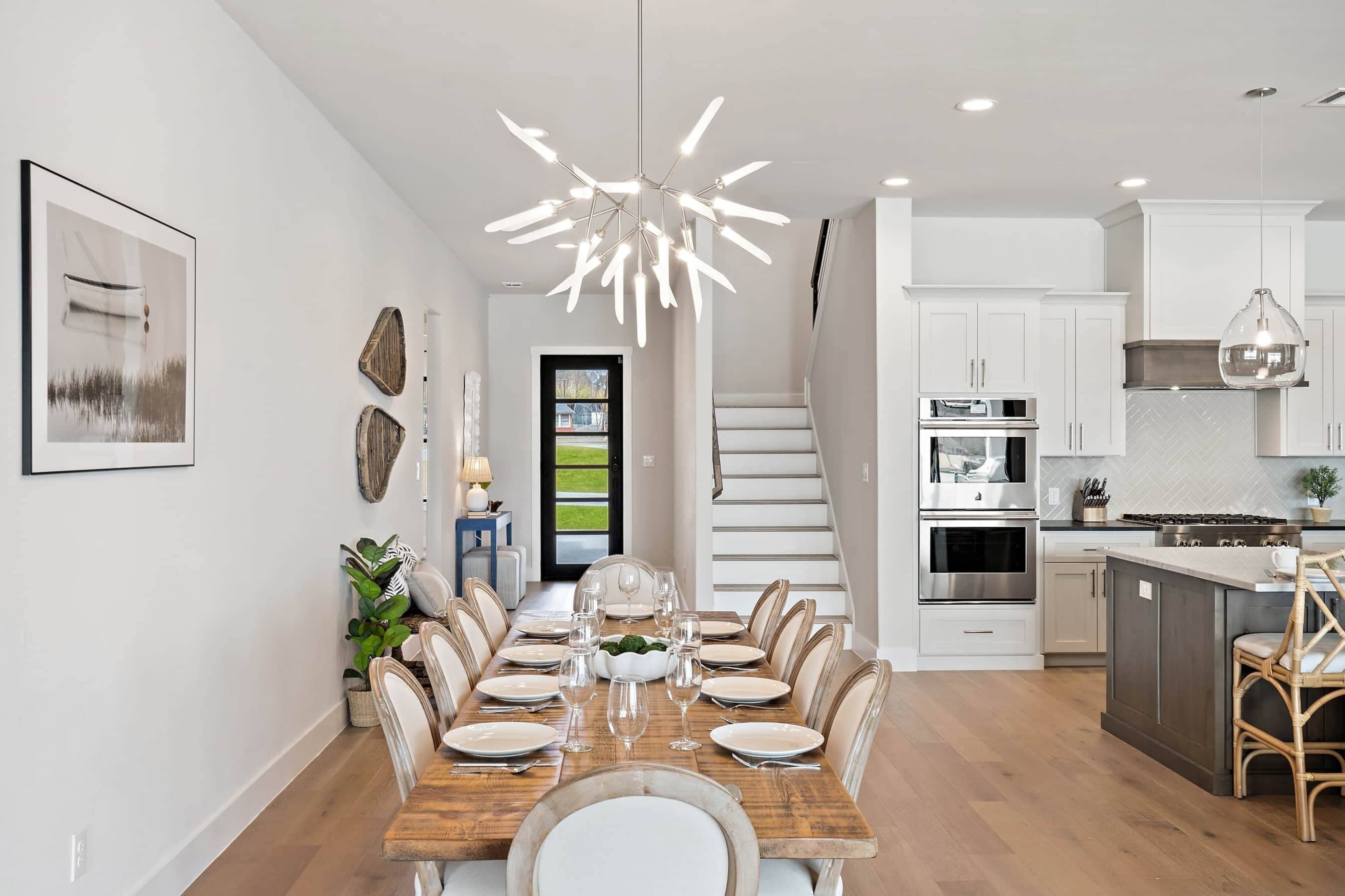 A modern kitchen with white cabinets, stainless steel appliances, and a wooden island.