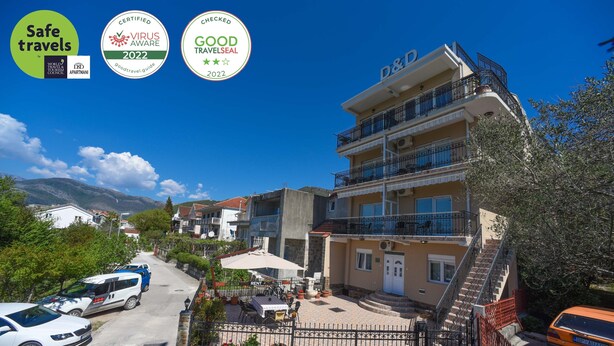 A multi-story building with balconies, a paved courtyard, and a view of the surrounding area.