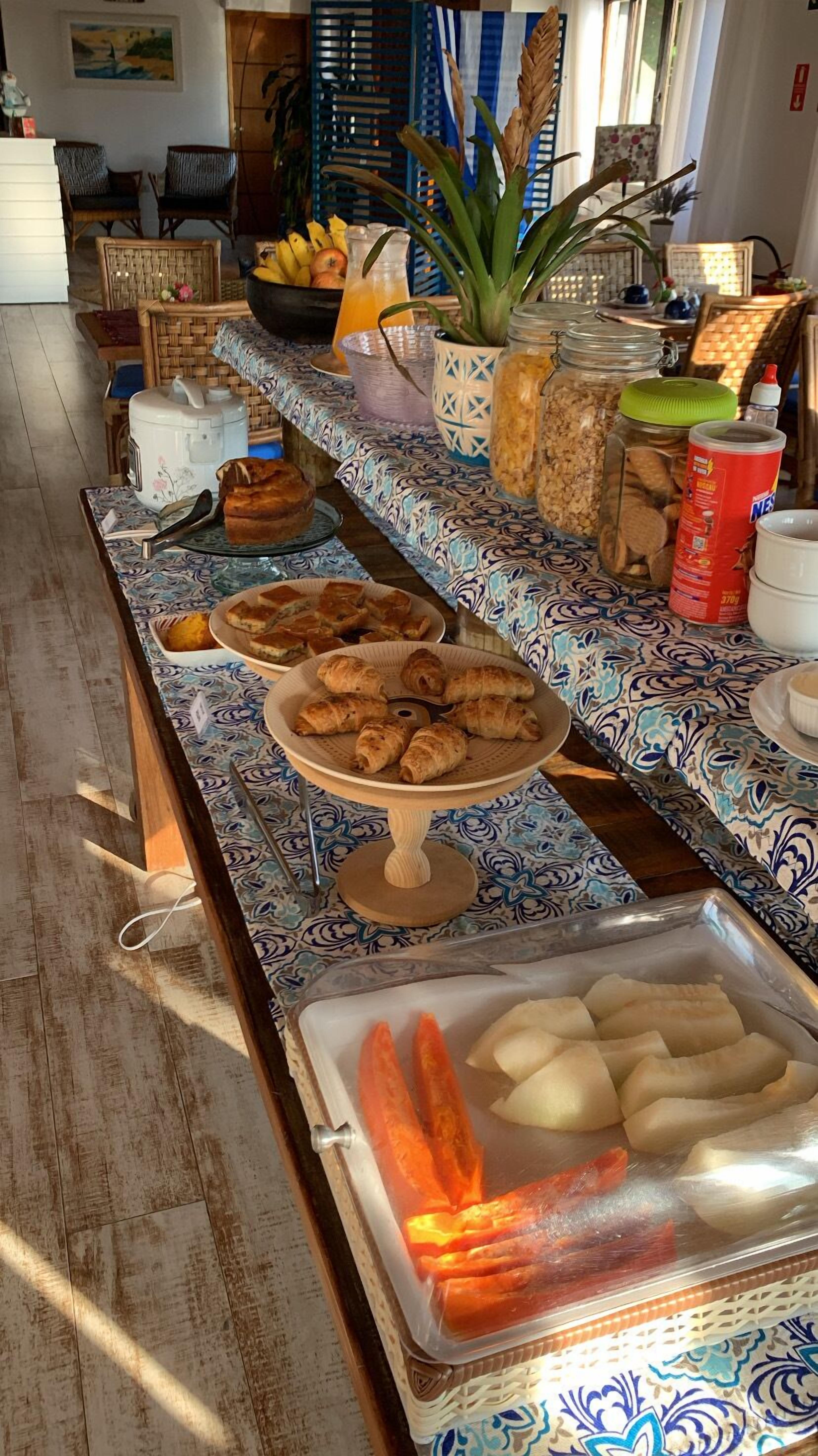 Una mesa de buffet con diversos alimentos y una planta decorativa.