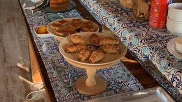 Una mesa de buffet con diversos alimentos y una planta decorativa.