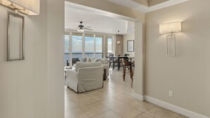 A spacious living area with a balcony, a dining area, and a ceiling fan. - Gulf Front Luxury Condo at Silver Beach Towers (Destin)