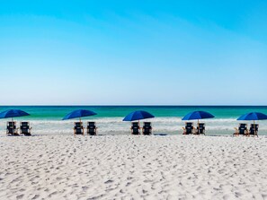 A beach with five rows of beach chairs and umbrellas, facing the ocean. - Gulf Front Luxury Condo at Silver Beach Towers (Destin)
