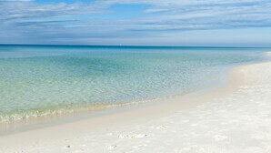 A beach with clear shallow waters and a sandy shore. - Gulf Front Luxury Condo at Silver Beach Towers (Destin)