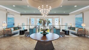 A spacious lobby with a central round table, seating arrangements, and a large chandelier. - Gulf Front Luxury Condo at Silver Beach Towers (Destin)