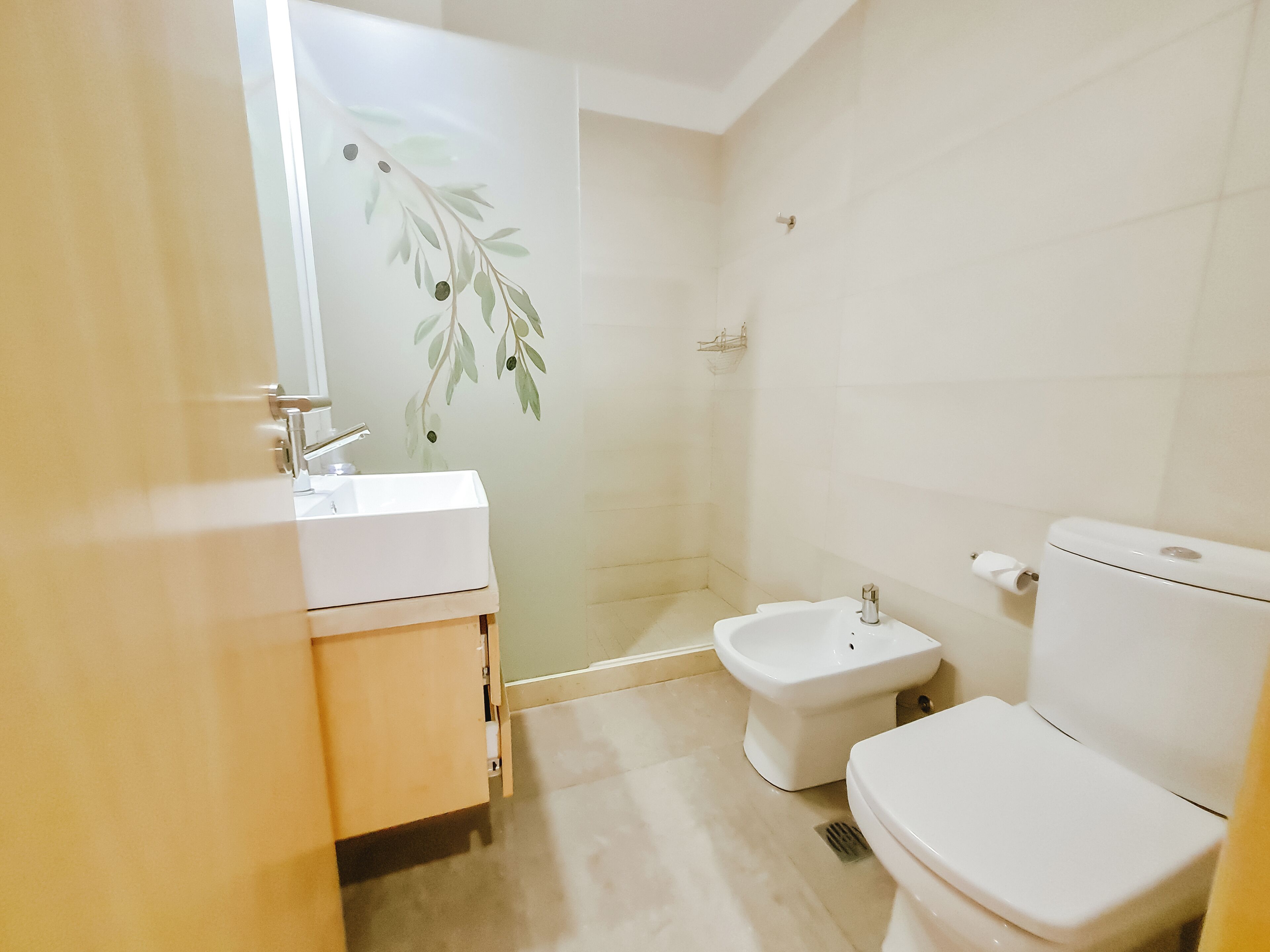 Un baño con lavamanos blanco, un bidé y un inodoro.