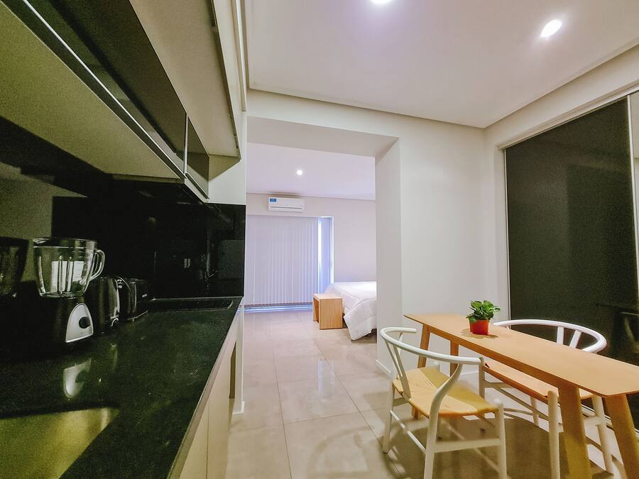 Una cucina moderna con macchina da caffè, frullatore e tostapane. C'è un'area pranzo con tavolo e sedie.