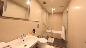 A modern bathroom with a sink, toilet, and glass-enclosed shower. - Hotel Regalia Tirupati (Tirupati)