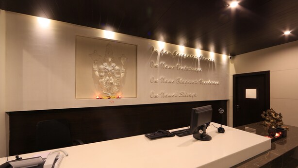 A reception desk with a computer, phone, and decorative items. - Hotel Regalia Tirupati (Tirupati)