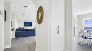 Una sala de estar moderna con un sofá, un comedor con mesa y sillas, y vista al océano.