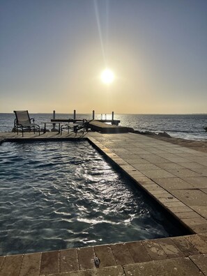 A pier extending into calm waters with a clear sky and the sun low on the horizon. - Waterfront House in the heart of Cudjoe Key.  (Summerland Key)