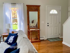 Relax in this inviting space with a sofa, wooden floor, and a wooden staircase.