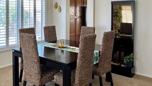 A dining area with a dark wooden table and six patterned chairs. A modern pendant light hangs above the table. - Diamond in the Desert💎🏝HEATED/COOLED Pool and Spa NO EXTRA CHARGE (Peoria)