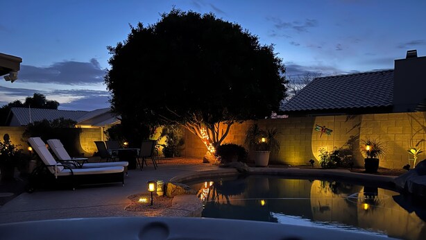 A pool area with lounge chairs and a hot tub, surrounded by a brick wall and potted plants. - Diamond in the Desert💎🏝HEATED/COOLED Pool and Spa NO EXTRA CHARGE (Peoria)