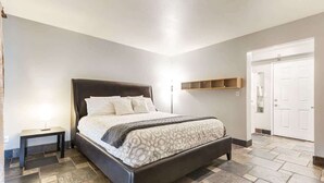 Une chambre à coucher avec un grand lit, une table de chevet, une armoire et une porte.