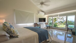 A bedroom with a bed, a television, a desk, and a chair. - Private Villa with Pool and Golf Cart (San Rafael del Yuma)