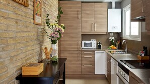 Una cucina moderna con mobili in legno, una parete in mattoni e un piano di lavoro nero.